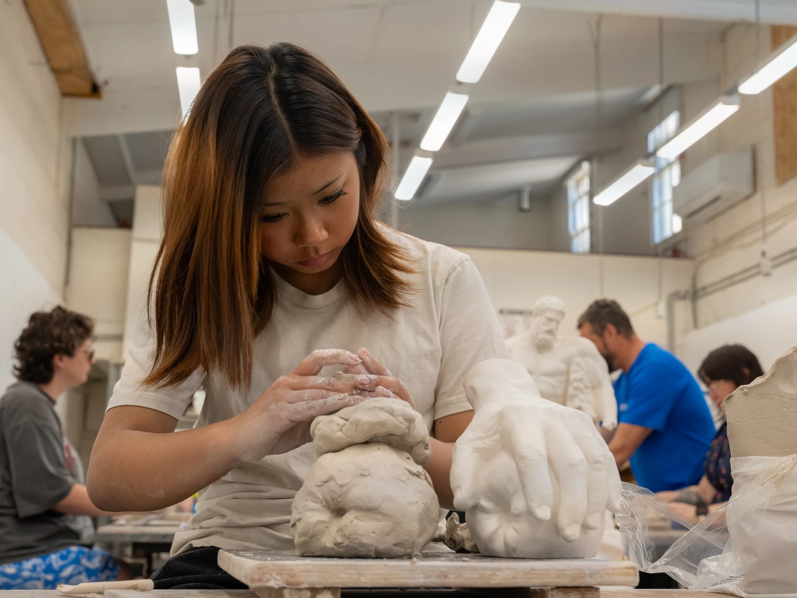 A visitor working with clay at Open Day