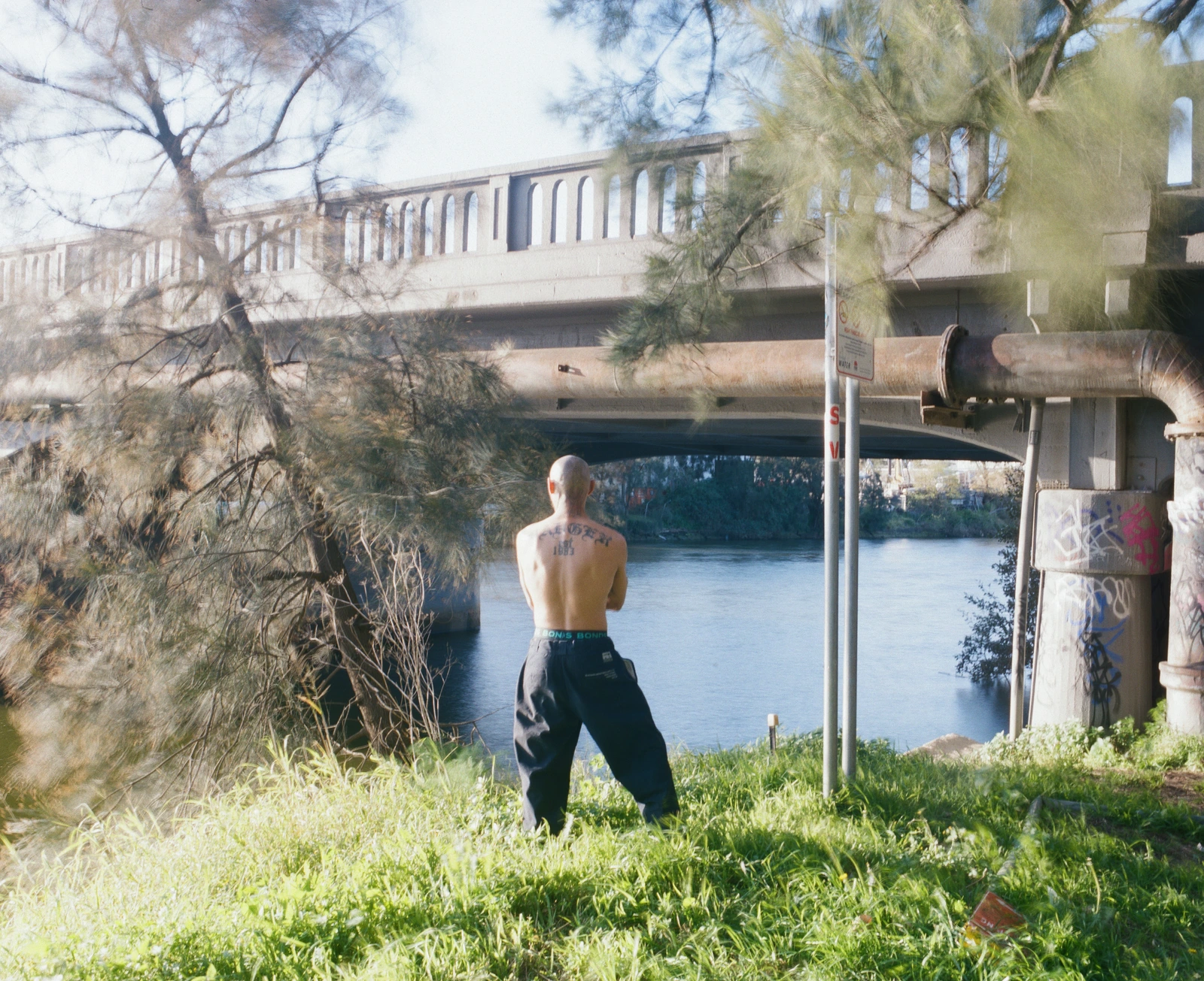 Jay - 2026 — Jay beside the water beneath a bridge