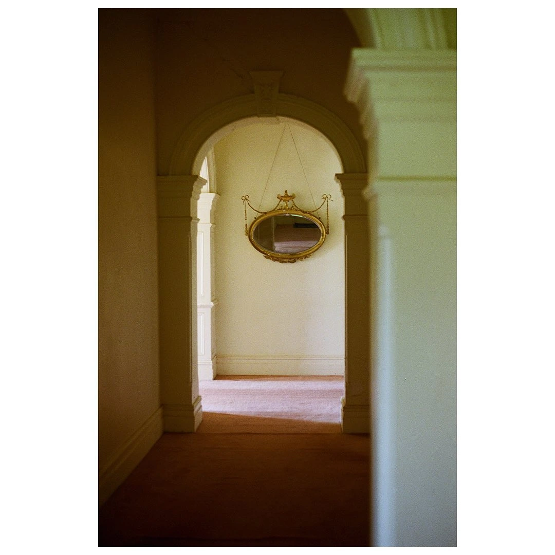 Untitled - 2021 — An empty hallway with an arched doorway and a mirror